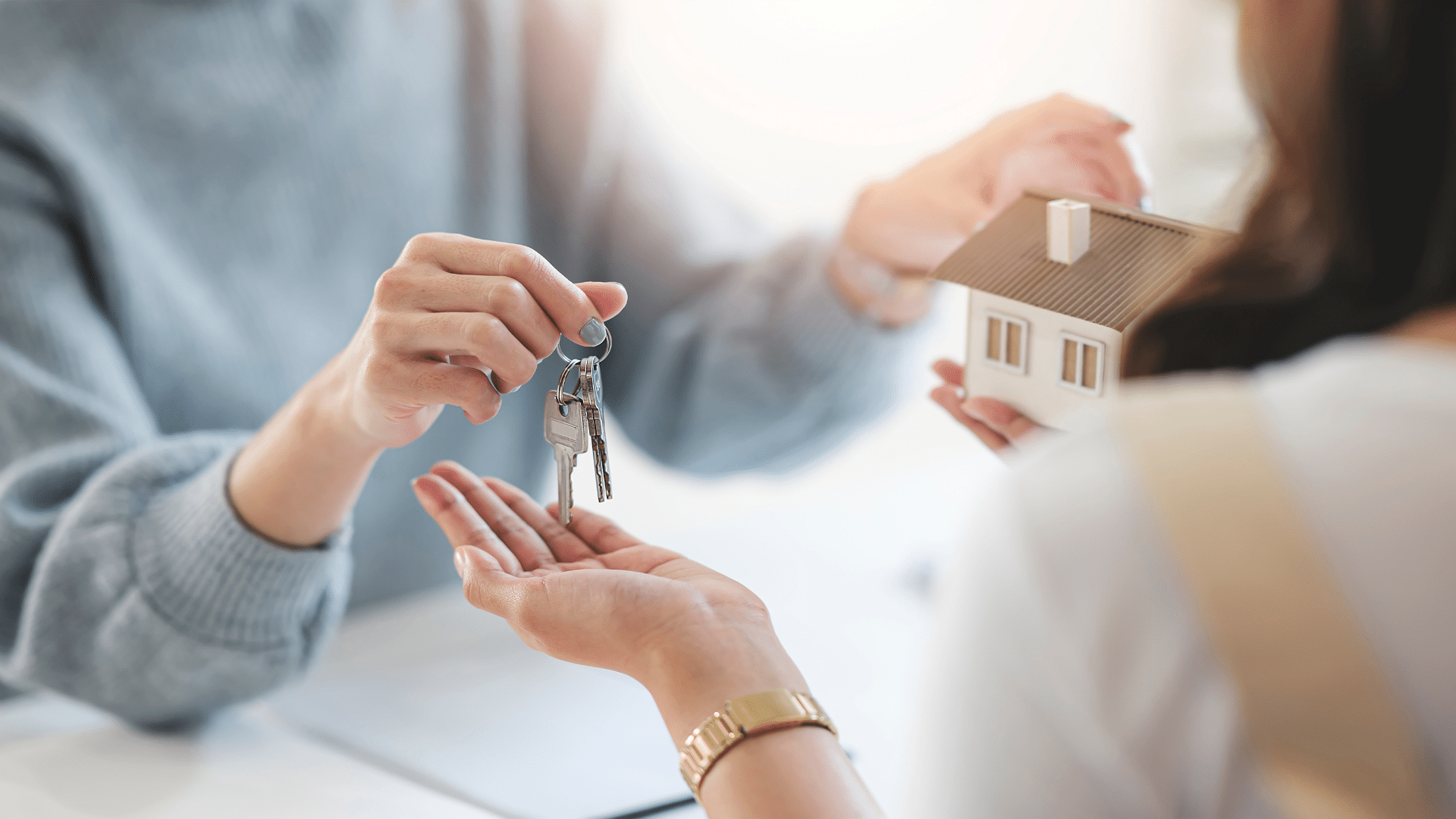agente immobilière qui remet des clés d'une maison à une acheteuse