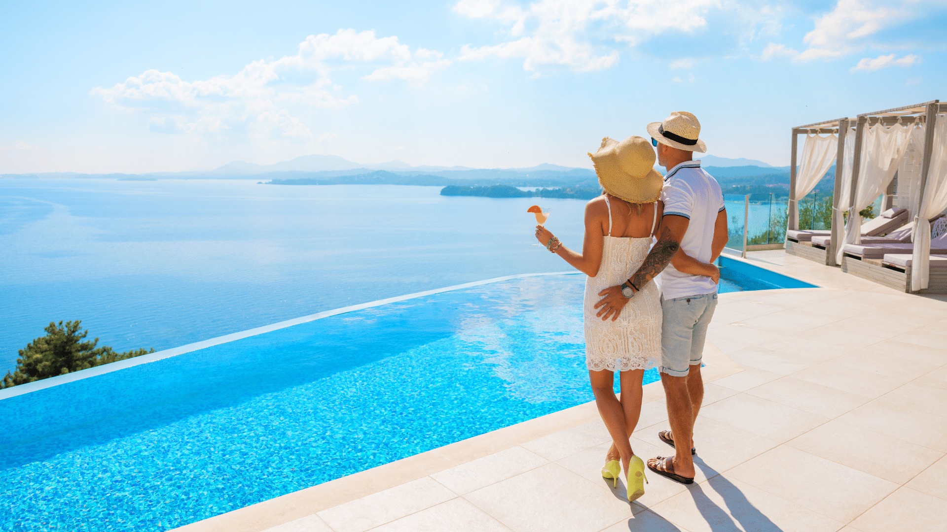 couple au bord d'une piscine dans une villa face à la mer